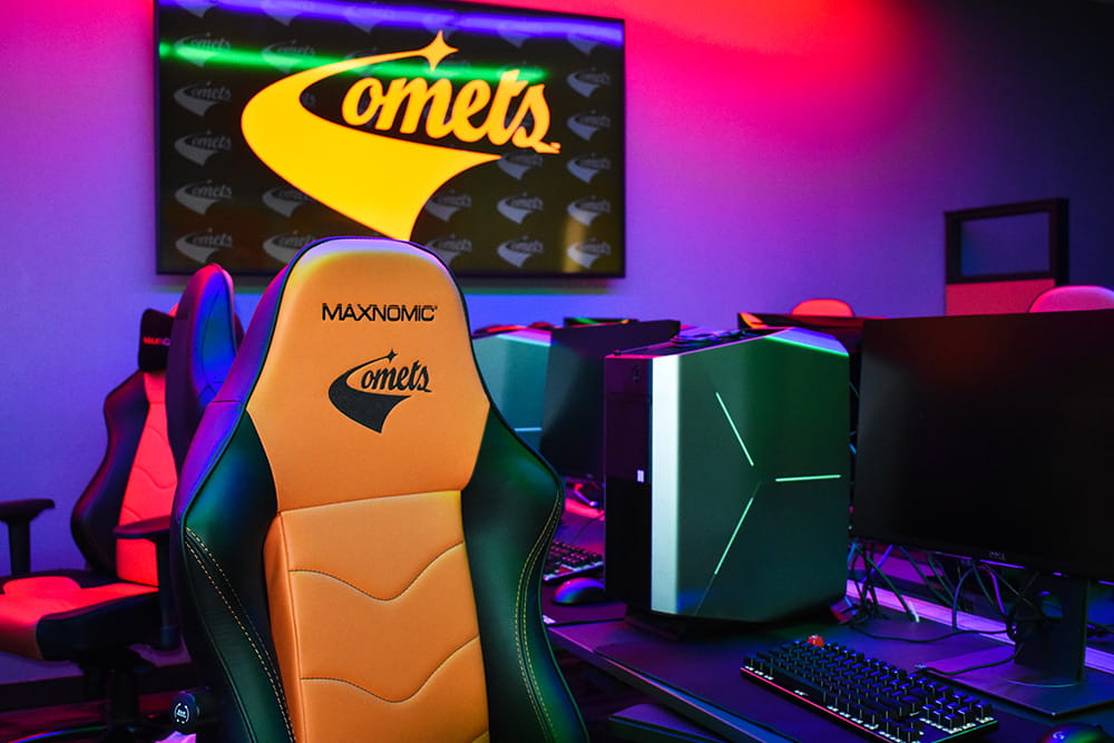 Monitor and gaming chair displaying a stylized Comets logo.
